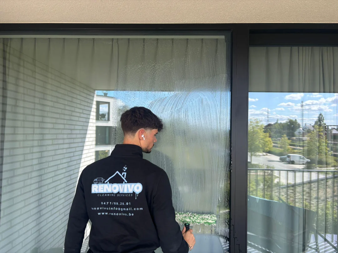 Professionele raamreiniger van Renovivo wast grote ramen voor een helder en streepvrij resultaat, beschikbaar in West- en Oost-Vlaanderen.